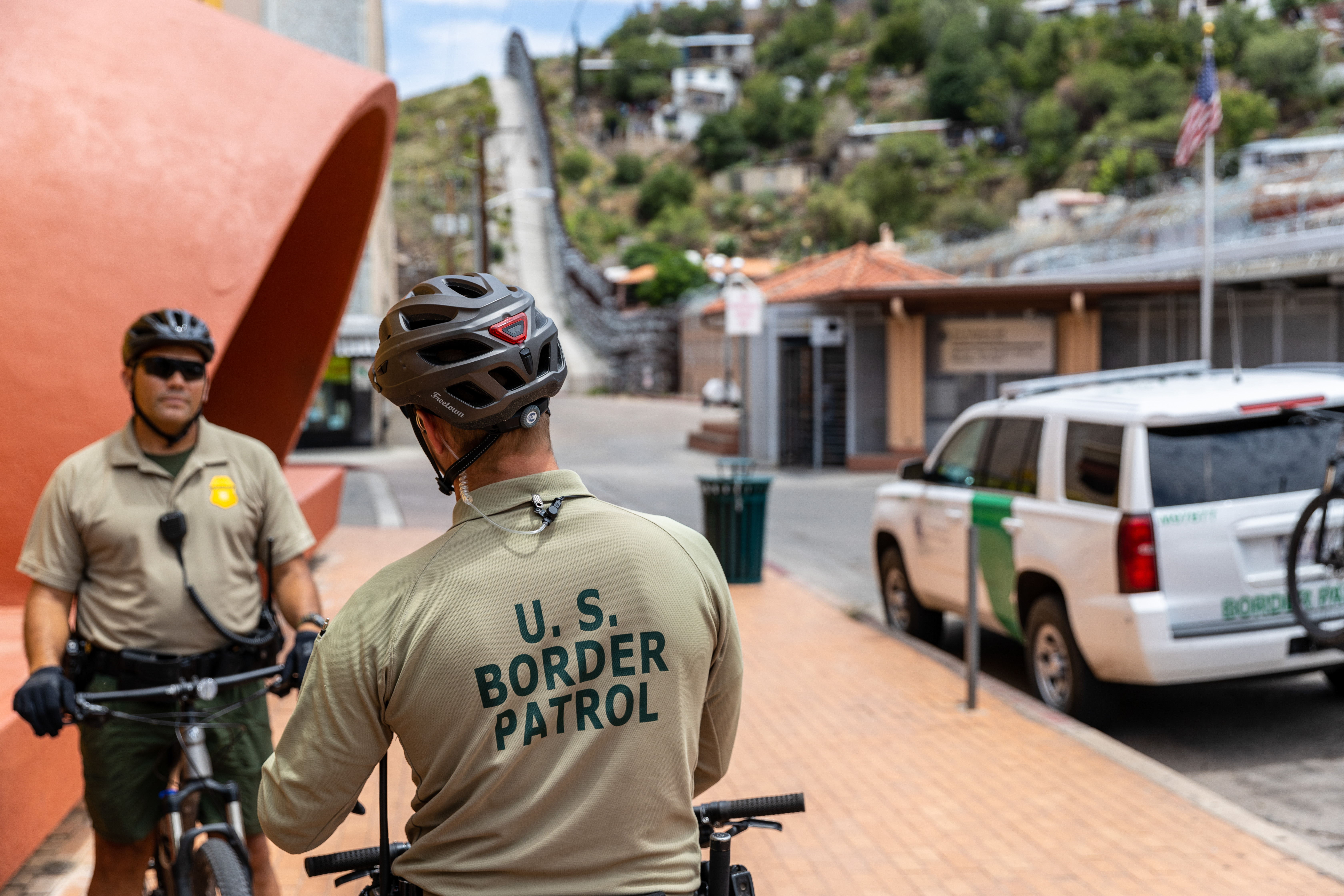 Picture of border patrol agents on bike looking at each other